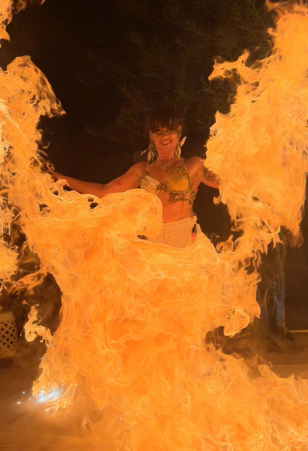 Darby Herrera in a fiery performance at a local venue fearlessly dancing with flames all around her.